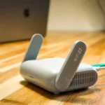 Router WiFi modern dengan antena di atas meja kayu